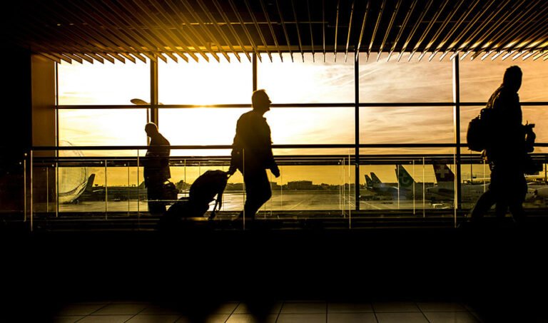Pasajeros con equipaje en un aeropuerto.