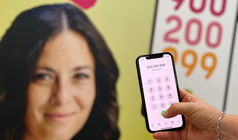 Una mujer llama al teléfono andaluz gratuito de atención a las mujeres.