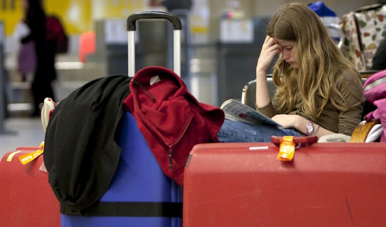 Una viajera espera en el aeropuerto, junto a su equipaje, la salida de su vuelo. (Foto EFE)