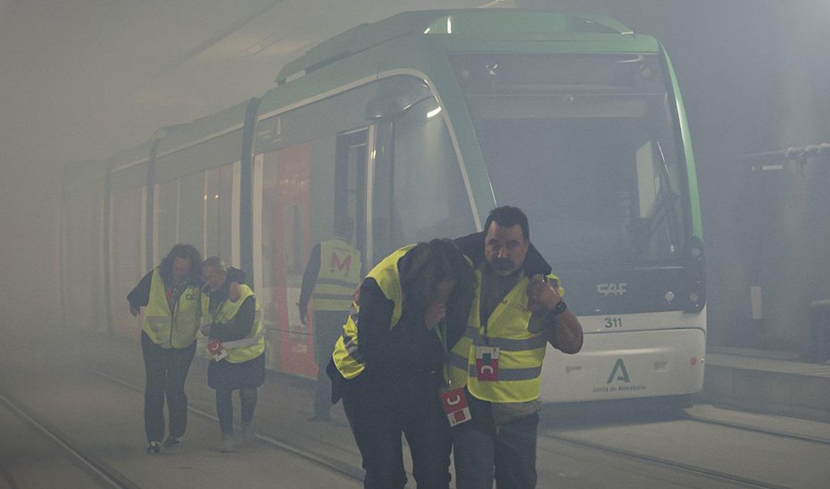 Empleados de Metro de Granda evacúan a dos figurantes heridos durante el simulacro de incendio que se ha llevado a cabo en el túnel de Camino de Ronda, entre las estaciones de Méndez Núñez y Recogidas.